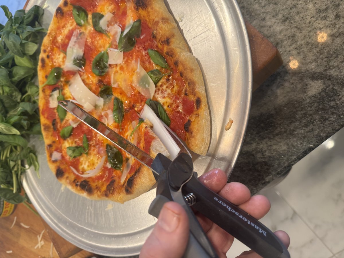 Master Schere cutting pizza — knife and board in one